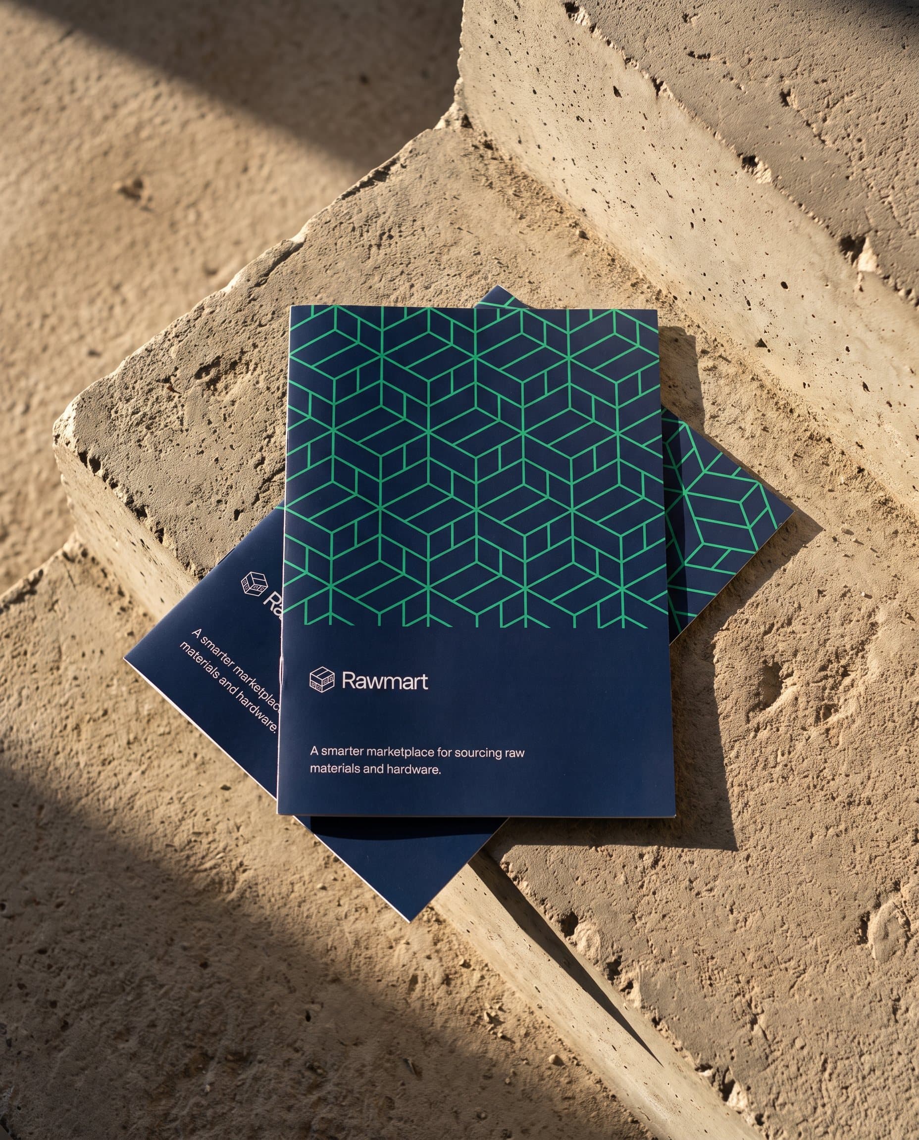 Rawmart brochures with the module pattern on the cover, on a concrete step