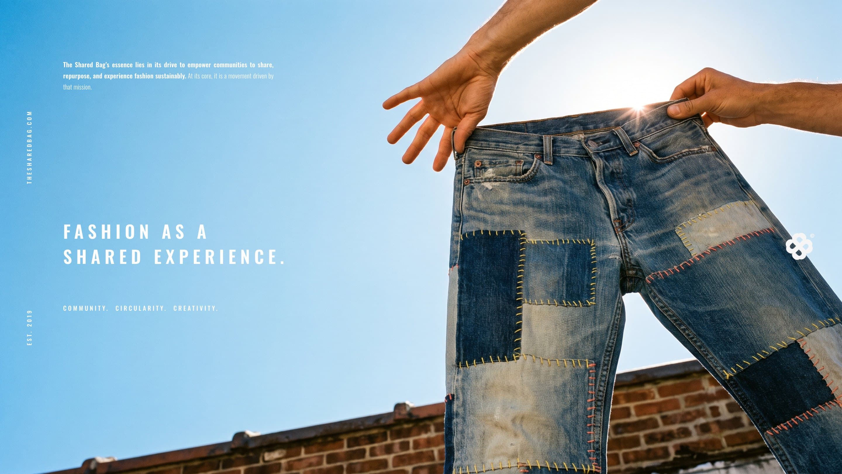 Upcycled patchwork jeans held up to the sky: Fashion as a shared experience.