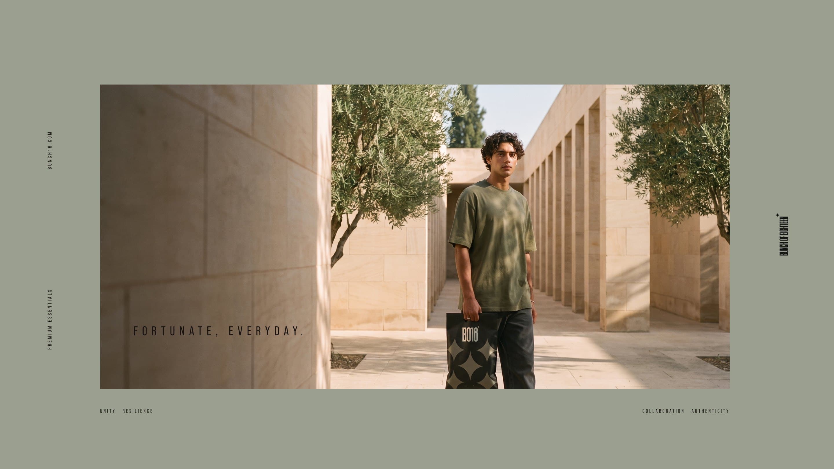 A model in an olive BO18 tee walks through a sunlit sandstone colonnade carrying the black BO18 mailer: Fortunate, everyday.