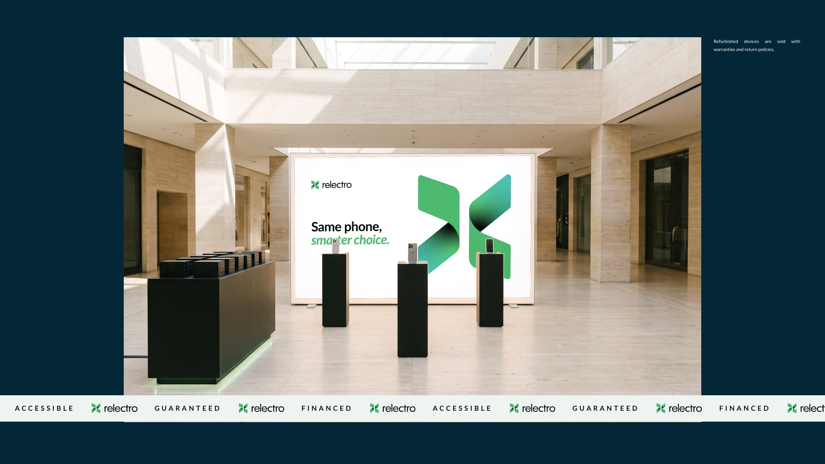 A Relectro pop-up in a travertine mall atrium, its lightbox printed with the ribbon mark and Same phone, smarter choice., iPhones on black plinths, the band of Accessible, Guaranteed and Financed across it