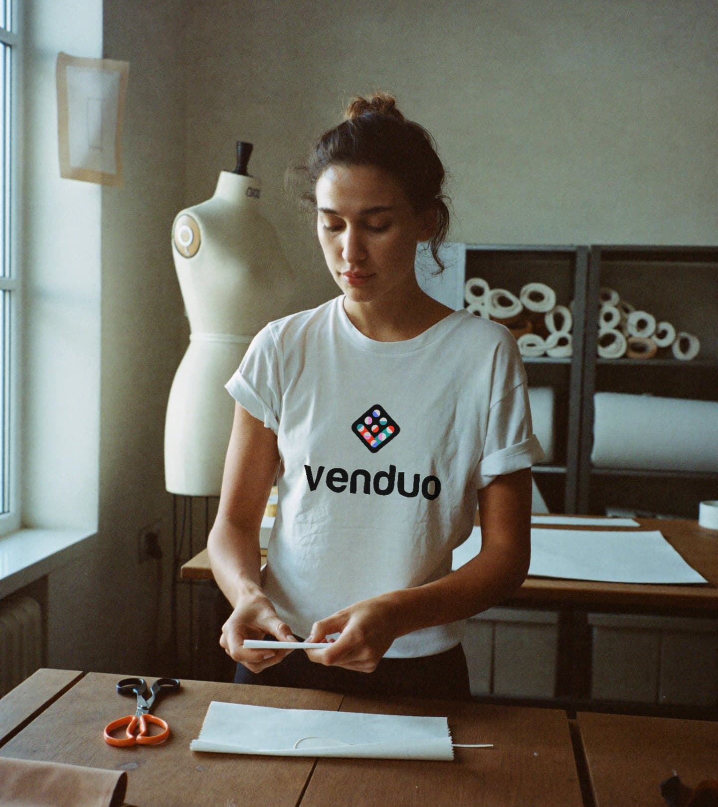 A fashion founder at her cutting table in a white Venduo tee
